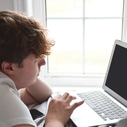 صورة مراهق وراء الكمبيوتر