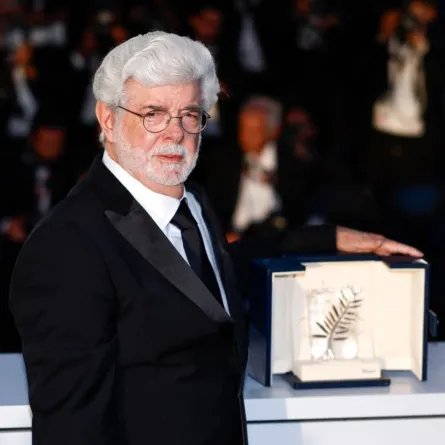 جورج لوكاس مع السعفة الذهبية الفخرية له في الدورة الـ77 لمهرجان كان السينمائي في مدينة كان جنوب فرنسا (George Lucas with his Honorary Palme d’Or at the 77th edition of the Cannes Film Festival in Cannes, southern France). مصدر الصورة: Sameer Al-Doumy / AFP