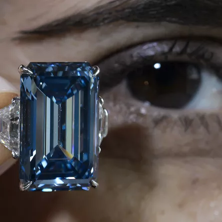 عارضة تحمل حجر أوبنهايمر الأزرق خلال عرضه في مزاد كريستيز