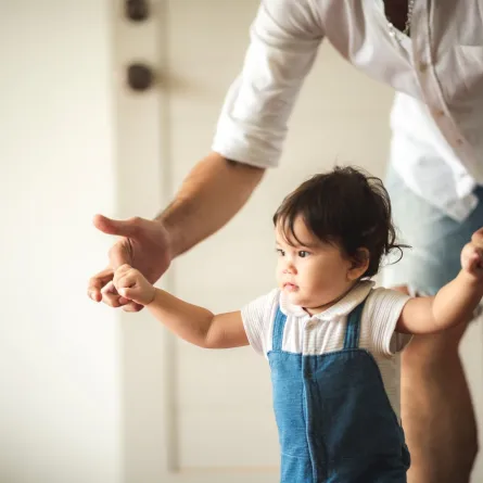 صورة أب يساعد طفله على المشي