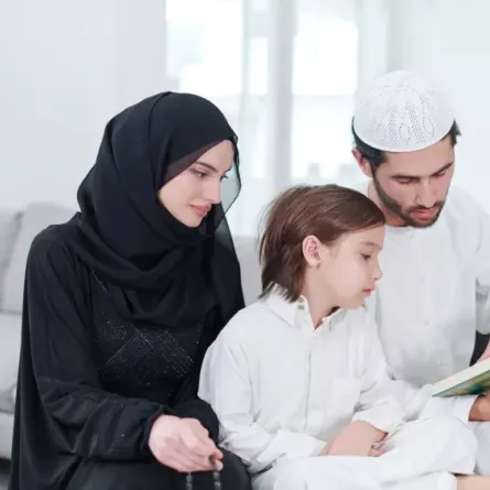 صورة لوالدين يحرصان على تعليم طفلهما طقوس عيد الأضحى