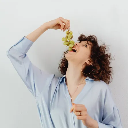 امرأة تتناول العنب