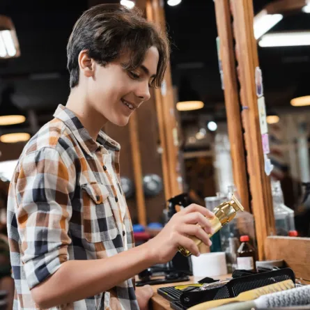 صورة مراهق يعمل في محل حلاقة 