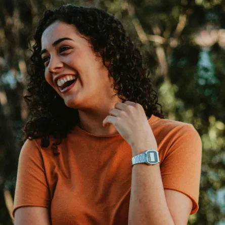 فتاة تضع يدها على رقبتها وهي تضحك