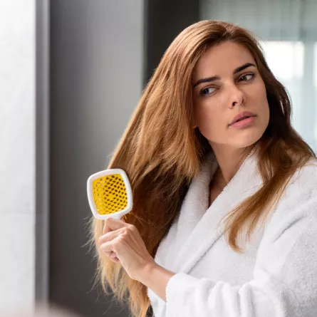 امرأة تقوم بفرد شعرها المصبوغ