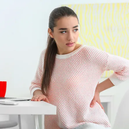 امرأة تعاني من ألم الظهر