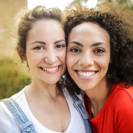 صديقتان سعيدتان تبتسمان بمودة