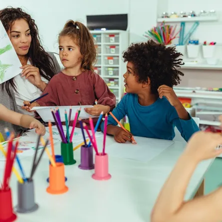 صورة لمعلمة الحضانة تتوسط الأطفال