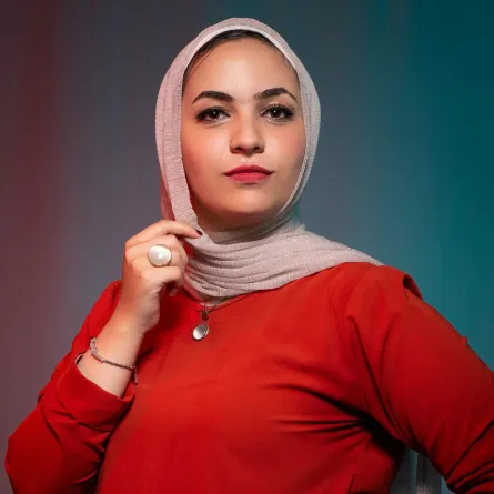 فتاة قوية تقف بثبات ترتدي فساتانا احمر اللون