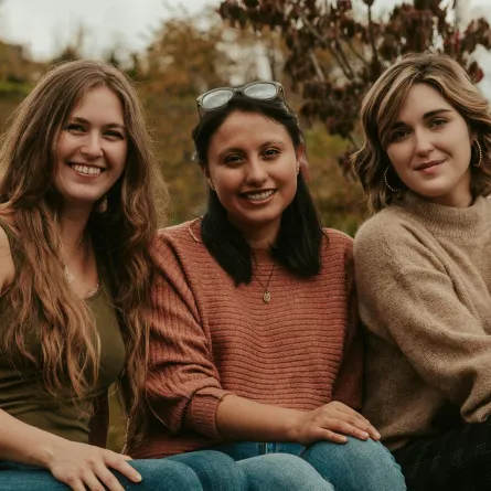 مجموعة من الصديقات يجلسن معا ويبتسمن بسعادة