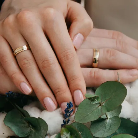 زوجان يضعان أيدهما فوق بعض تظهر دبل الزواج 