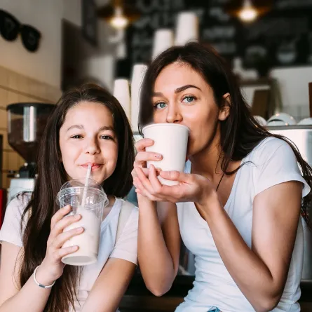 صورة لأم تتناول مشروب مع طفلتها