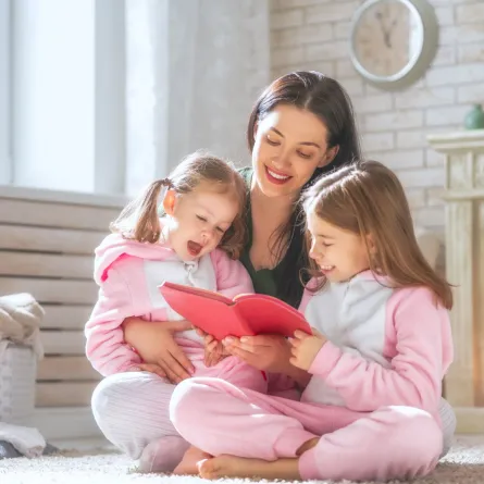 صورة أم تقرأ القصص لطفلتيها