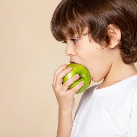 صورة لطفل يتناول التفاح الأخضر