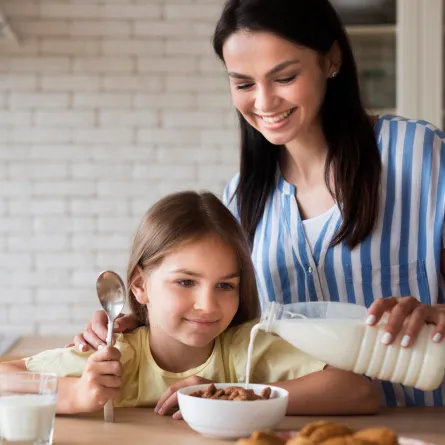 صورة لأم تصب اللبن لطفلتها