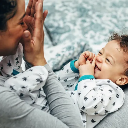 صورة لأم تلعب مع رضيعها لعبة الغميضة