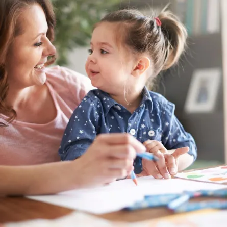 صورة لأم تعلم طفلتها النطق والتهجي للحروف