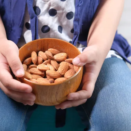 صورة طفلة تحمل اللوز