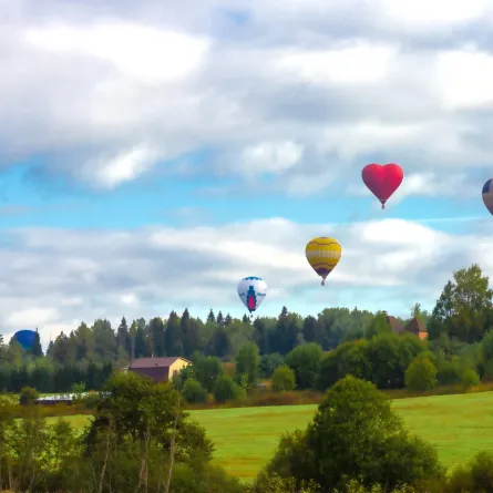 بالونات الهواء الساخن في السماء الزرقاء مع السحب