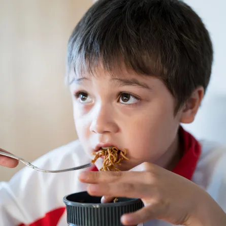 صورة طفل يأكل الطعام الصيني