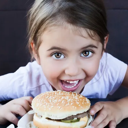 صورة لطفلة تتناول ساندوتش