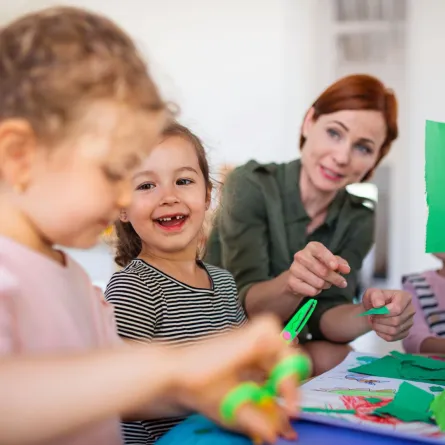 طفلتان وأمهما يصنغون البطاقات