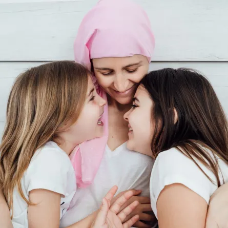 صورة أم مصابة بالسرطان مع طفلتيها