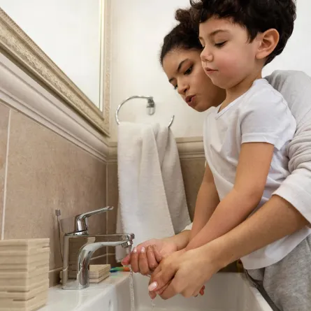 صورة لأم تعلم طفلها غسل اليدين