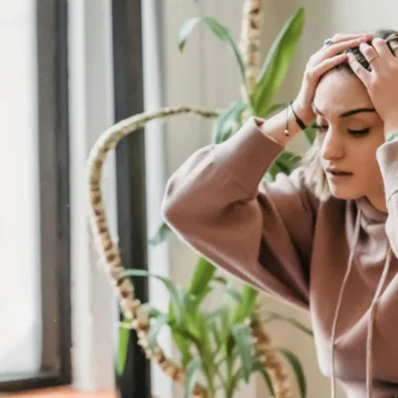 شابة تواجه الانتقادات بضيق وترفع يديها فوق رأسها  