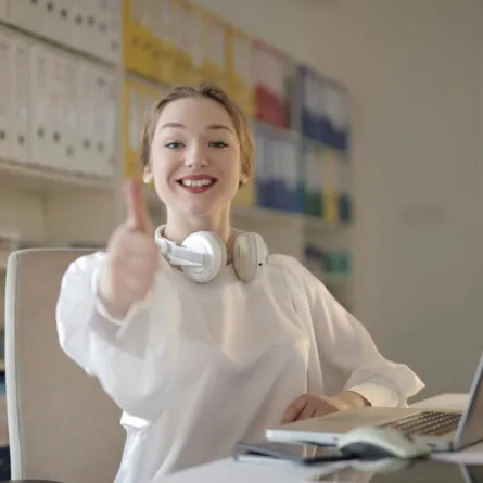 فتاة تبدو ناجحةً وقد حققت أحد أهدافها فتشير بعلامة النصر