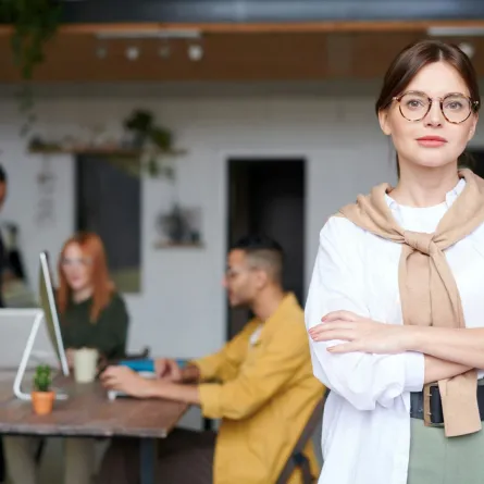 شابة تقف عاقدة ذراعيها حول بعضهما في ثقة 