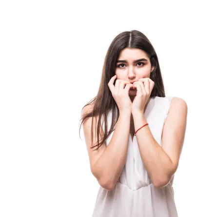 فتاة تبدو خجولة تخبئ فمها بكلتا يديها 