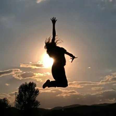 فتاة سعيدة تقفز لأعلى من فرط فرحتها بالحياة