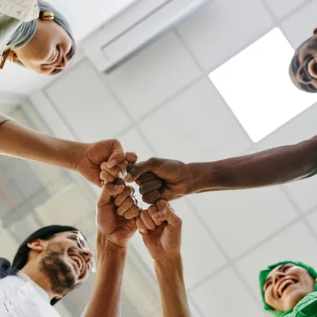 مجموعة من الشباب يضمون قبضاتهم معاً علامة على التوافق