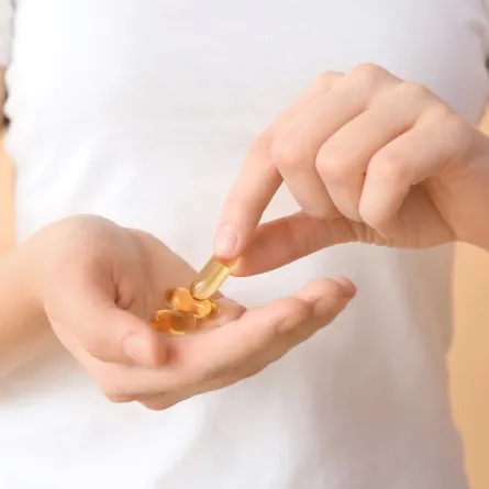 صورة لامرأة تتناول كبسولة من حمض اوميغا 3