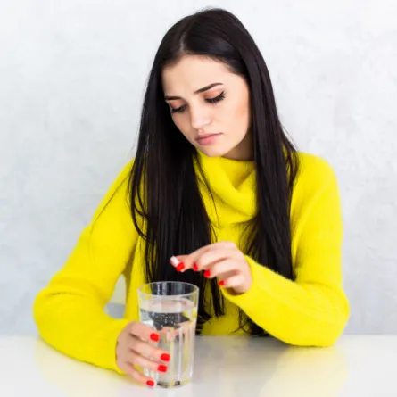 امرأة تتناول مكمل الحديد - المصدر freepik