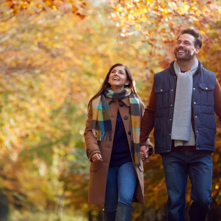 زوج وزوجة يتنزهان معاً في الطبيعة وتبدو علامات الحب والانسجام عليهما 