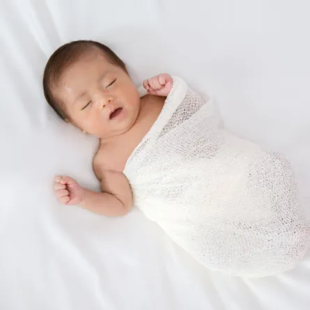 صورة لمولود نائم وهو مفتوح نصف العينين