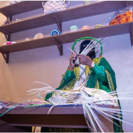 سيدة سعودية تستخدم الخوص في صناعة حرف تراثية