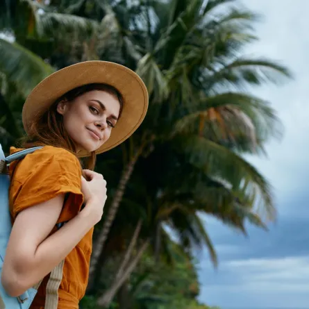 مسافرة تحمل حقيبتها وقبعتها