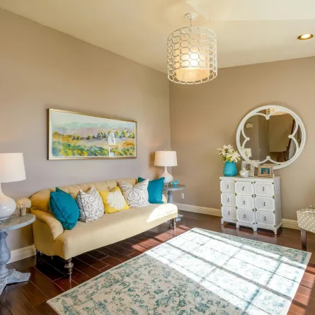 غرفة معيشة مؤثثة بقطع أثاث وديكور ذات ألوان زاهية