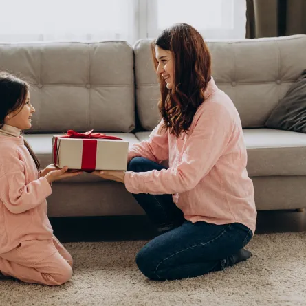 صورة لأم تعطي طفلتها هدية