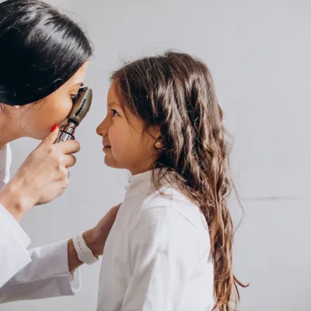 صورة لطبيبة تفحص عيون طفلة