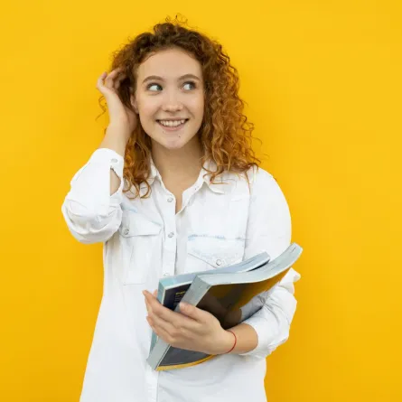 فتاة متفائلة تمسك بيدهل عدداً من المجلات تطالعها مع بداية العام الجديد