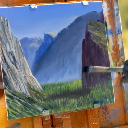 فنان تشكيلي يرسم لوحة بألوان زيتية