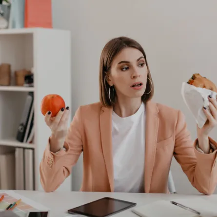 امرأة حائرة بين الطعام الصحي والأطعمة السكرية- المصدر freepik