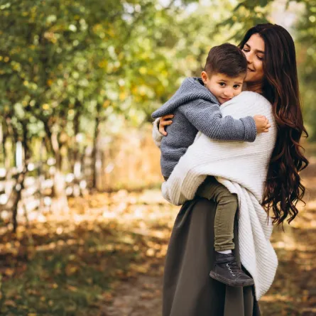 صورة لأم تحتضن طفلها في الطبيعة