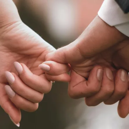 زوجان يمسك كل منهما بإصبع الآخر الصغير دليل على قوة علاقتهما