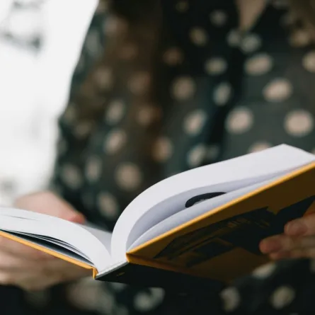 فتاة تفتح كتابًا تقرأه