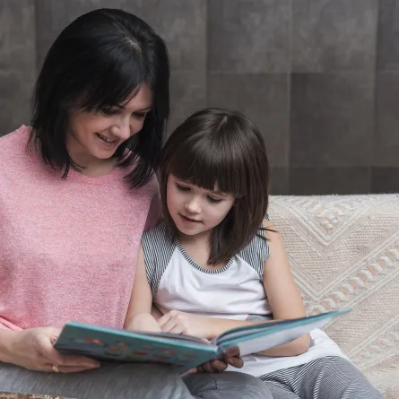 صورة لأم تقرأ لطفلتها